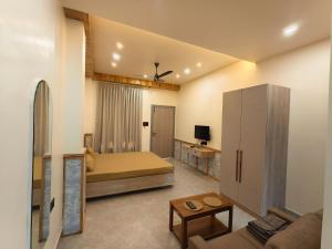 a bedroom with a bed and a living room at Cordial Host in Guwahati