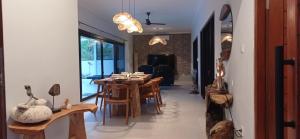 a dining room with a table and some chairs at Khrisna Mooi villa 2 BR in Tulamben