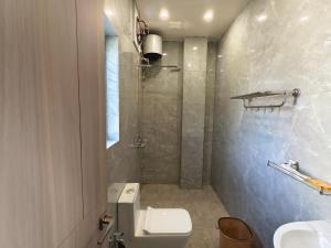 a bathroom with a toilet and a shower at Cordial Host in Guwahati +13 photos