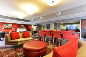 a hotel lobby with red chairs and a bar at Holiday Inn Express Painted Post by IHG in Painted Post
