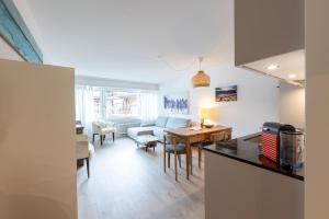 a kitchen and living room with a table and a couch at Apartment Tinus - 3 min Walk to Ski Lift in St. Moritz