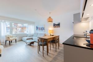 a kitchen and living room with a table and a couch at Apartment Tinus - 3 min Walk to Ski Lift in St. Moritz +17 photos