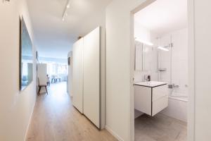 a white bathroom with white cabinets and a sink at Apartment Tinus - 3 min Walk to Ski Lift in St. Moritz