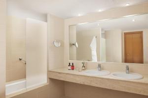 a bathroom with two sinks and a large mirror at iStay by NH Ciudad de Valencia Hotel in Valencia