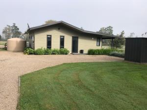 ein Haus mit einem Rasen davor in der Unterkunft Country Cottage Centrally Located in Tauwhare
