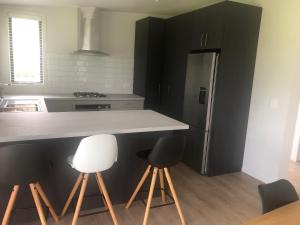 eine Küche mit Theke und Kühlschrank in der Unterkunft Country Cottage Centrally Located in Tauwhare