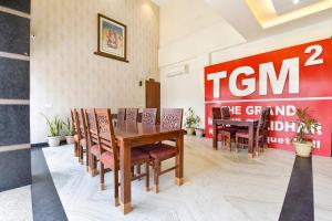 a dining room with a table and chairs and a sign at FabHotel The Grand Manmuralidhar - Hawa mahal 3 km, Chandpol metro station in Jaipur