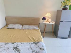 a bed in a room with a refrigerator and a table at Phương Đông 502DT in Hanoi