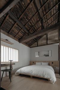a bedroom with a large bed and a desk at Haku-ma 白間 in Kanazawa