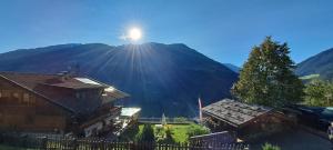 De zon schijnt op een berg achter een huis. bij Großstahlhof Mountain & Panorama View in San Giovanni in Val Aurina