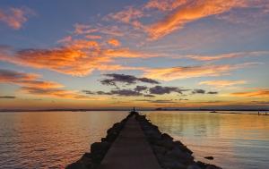 a pier in the water with a sunset at Cuca roses in Roses
