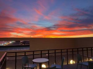 Una puesta de sol en un balcón con mesas y sillas en ANA Crowne Plaza Hotel Kushiro by IHG, en Kushiro