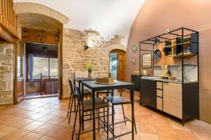 Una cocina con una mesa y sillas en una habitación. en Apulia Luxury House, en Toritto 25 fotos más
