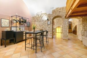 Una cocina y un comedor con mesa y sillas. en Apulia Luxury House, en Toritto