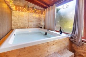 a large white tub in a room with a window at Apulia Luxury House in Toritto