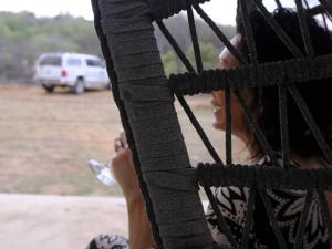 Una mujer sosteniendo una botella de agua detrás de una valla. en The Beehive Cabin, en Rhenosterfontein 3 fotos más