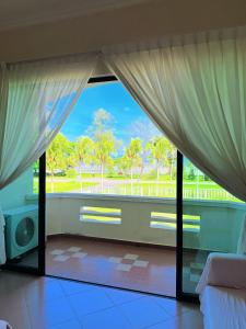 a bedroom with a large window with a view of a park at Met Blue Ocean Resort in Mersing