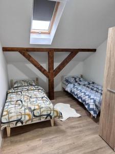 a attic bedroom with two beds and a window at La Casa 2 in Sombor
