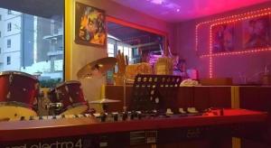 a room with drums and a counter with pink lights at Super Hostel in Nonthaburi