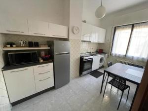 een keuken met een koelkast en een tafel. bij Sweet 16 in Rapallo