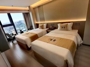 ein Hotelzimmer mit zwei Betten und einem großen Fenster in der Unterkunft Su Lu Hotel in Guiyang
