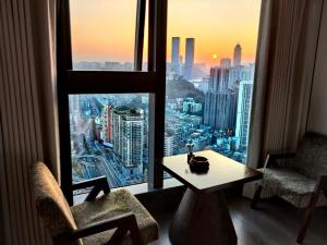 ein Raum mit einem Tisch und zwei Stühlen und einem Fenster in der Unterkunft Su Lu Hotel in Guiyang