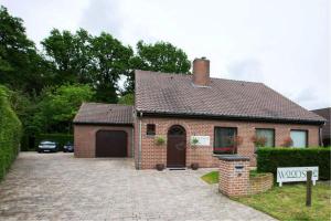 a brick house with a driveway in front of it at B&B Woodside in Torhout