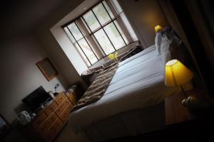 a bedroom with a large bed with a window at Airlie House Self Catering in Strathyre