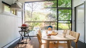 Pocheon luxjay pet Pension في بوتشون: طاولة وكراسي في غرفة ذات نافذة كبيرة