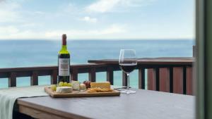 una botella de vino y un plato de queso y una copa en Youngduk Sea & Spa Pension, en Yŏngdŏk