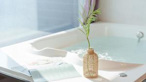 un jarrón con una planta en él sentado en un fregadero en Youngduk Sea & Spa Pension, en Yŏngdŏk