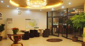 a lobby with tables and chairs in a building at GreenTree Inn Chaoyang Shuangta District Bus Station in Chaoyang