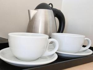 two coffee cups and a tea kettle on a shelf at El Toro Motel in Warwick Farm