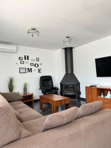 een woonkamer met een bank en een open haard bij Seahomes Vacations - Charming House with Private Pool in Santa Susanna