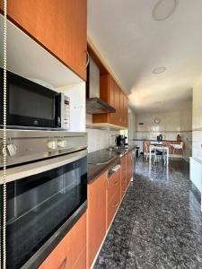 een keuken met een magnetron en een fornuis bovenste oven bij Seahomes Vacations - Charming House with Private Pool in Santa Susanna