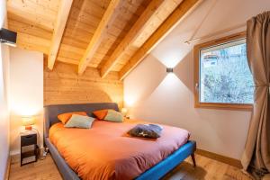 a bedroom with a bed in a room with a window at Chalet cosy et neuf, Grande Terrasse, Vue panoramique in Saint-Jean-de-Sixt