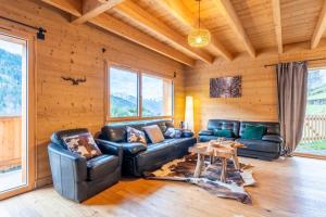 a living room with leather couches and a table at Chalet cosy et neuf, Grande Terrasse, Vue panoramique in Saint-Jean-de-Sixt