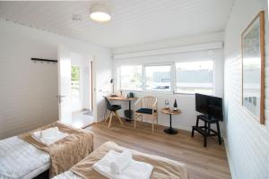 a room with a bed and a desk and a television at Hotel Lisboa in Frederikshavn