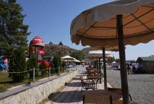 Un patio con mesas y sillas y una sombrilla. en Чичхани Chichxani Kambuz, en Aghk'ilisa 3 fotos más