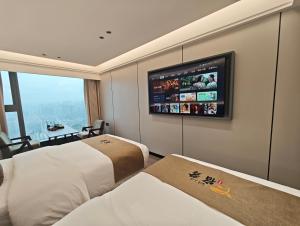 ein Hotelzimmer mit zwei Betten und einem Flachbildfernseher in der Unterkunft Su Lu Hotel in Guiyang + 22 Fotos