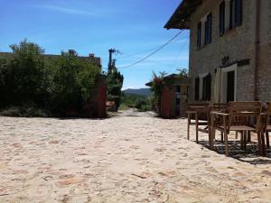 eine leere Gasse mit Stühlen und einem Gebäude in der Unterkunft Agriturismo Tenuta San Giuseppe in Cossano Belbo