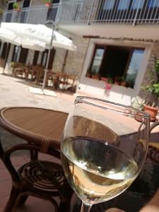 a glass of white wine sitting on a table at Agriturismo Tenuta San Giuseppe in Cossano Belbo