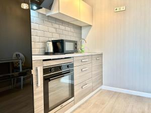 a kitchen with a stove and a microwave at Designer luxury Appartment in Kharkiv +7 photos