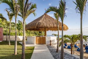 ein Resort mit Palmen und einem Strohschirm in der Unterkunft Cactus Village Penida in Nusa Penida