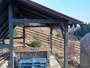 a building with a blue bench under a roof at Independent Chalet in Şirnea