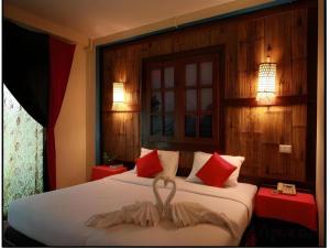 Una habitación de hotel con una cama con una toalla encima. en Phumanee Home Hotel, en Fang 201 fotos más