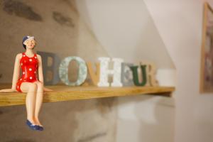 une poupée en robe rouge assise sur une étagère dans l'établissement studio 2 personnes rue travot, à Les Sables-dʼOlonne