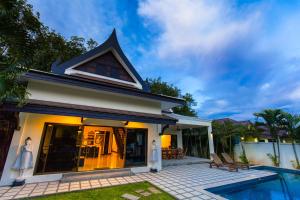 a villa with a swimming pool and a house at Champagne Villa by G Estate in Rawai Beach