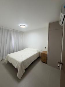 une chambre blanche avec un lit et une commode dans l'établissement Lanai Imbassai, à Mata de São João 7 autres photos