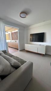 - un salon avec un canapé et une grande télévision dans l'établissement Lanai Imbassai, à Mata de São João